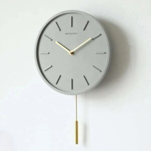 Nordische Zementwanduhr mit Metallpendel | Minimalistische skandinavische Uhr für modernes Interieur Hover Image
