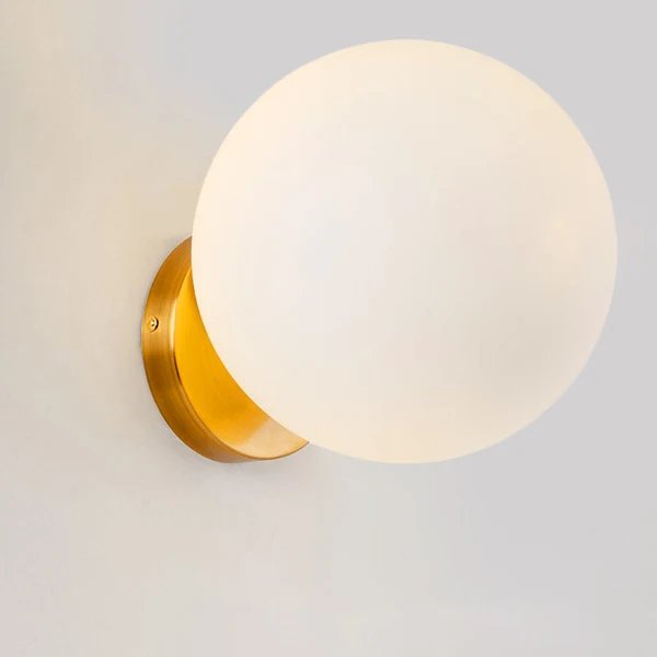 Wandleuchte mit mattem Glasball und goldener Wandhalterung